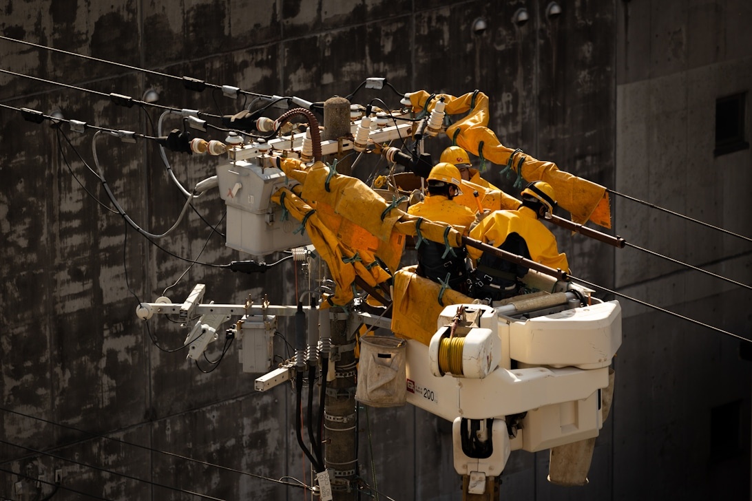 En elektrisk lastbil med liftkorg arbetar nära kraftledningar.